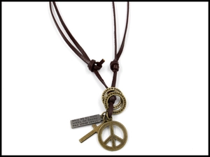 Detail of vintage peace sign and cross pendants on a brown leather cord necklace