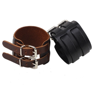 Détail des bracelets punk en cuir à double boucle dans les tons noir et marron foncé