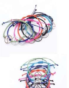 Detail of adjustable handmade wax string bracelets with silver wave charm in various colors