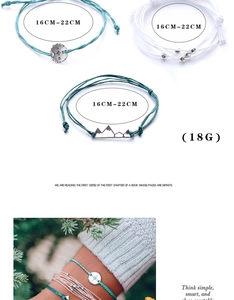 Detailed view of bohemian woven bracelets set with mountain and compass charms
