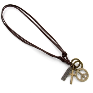 Vintage leather peace sign and cross pendant necklace with bronze charms on white background