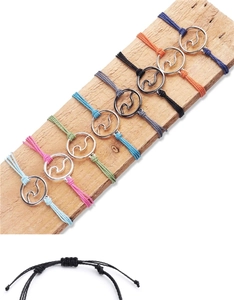 Detail of colorful handmade wax string bracelets with silver surfing wave charms on wood