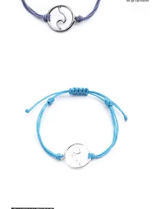 Detail of handmade wax cord bracelets featuring silver wave charms and adjustable closures