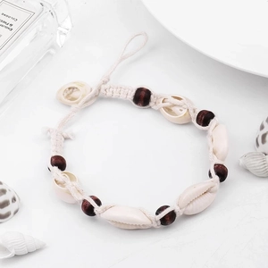 Bohemian handmade wood bead and seashell anklet for women on a fresh marine background