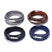 Détail de quatre bracelets enveloppants en cuir coloré avec perles et fermoir magnétique