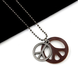 Macro view of retro double-layer peace sign pendants with leather and metal details