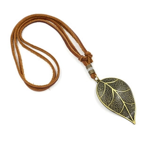 Detailed view of vintage bronze leaf pendant with intricate carvings on brown leather cord