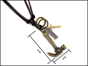 Macro shot of bronze hammer pendant with skull relief and cross on leather cord