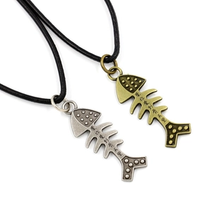 Detail of fish bone pendants in silver and bronze with engraved romantic Chinese text