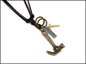 Macro shot of punk leather cord necklace featuring bronze hammer and cross pendants