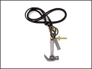 Detailed close-up of punk leather cord necklace with vintage hammer and cross charms
