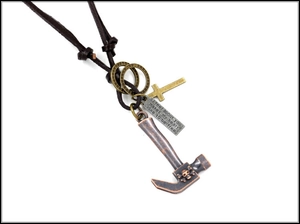 Close-up of retro punk necklace with bronze hammer, skull, and cross pendants on leather cord
