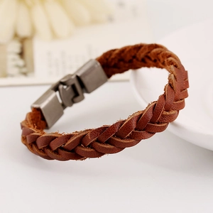 Bracelet unisexe en cuir tressé marron avec fermoir magnétique argenté sur plateau blanc