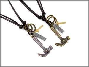 Close-up of vintage punk alloy hammer and cross pendants on leather cord necklaces