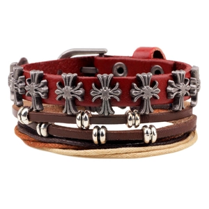 Détail d'un bracelet en cuir multicouche avec croix à fleurs en métal et corde tressée