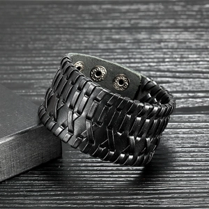 Pulsera punk de cuero trenzado para hombre con botones de presión plateados sobre fondo de madera