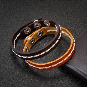 Set of two handmade braided leather bracelets in dark brown and orange with metal snaps
