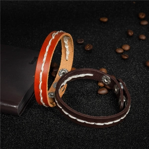 Handmade woven leather bracelet in orange and brown with rustic stitching and metal clasp