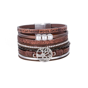 Macro detail of multi-layer leather bracelet with tree of life charm and rhinestones