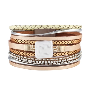 Detail of bohemian multilayer leather bracelet with shell charms and crystal rhinestones