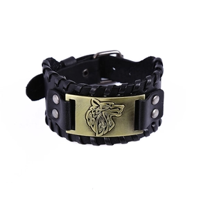 Detail view of black leather bracelet featuring bronze wolf head relief and woven edges