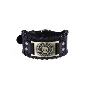 Detail of a Viking leather bracelet featuring a vintage golden Nordic rune metal plate