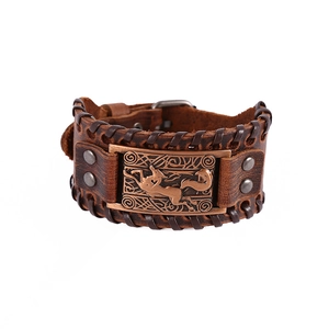 Close-up of vintage brown leather bracelet featuring a bronze fox emblem and Celtic knot detail