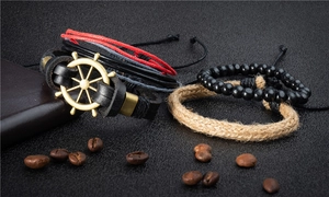 Dettaglio di un set di braccialetti in pelle stile navy con ciondolo a timone e perline
