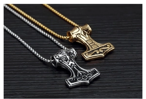 Close-up of Thor's hammer pendants in gold and silver finish with detailed engravings