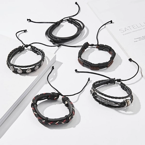 Detail view of five-piece vintage braided leather bracelet set with metallic charms