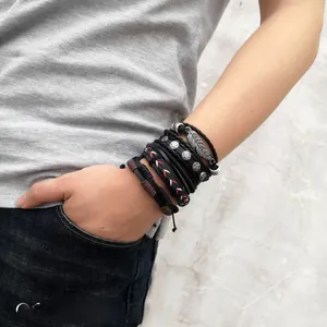 Detail view of multi-layer braided leather bracelets with feather and star metal charms