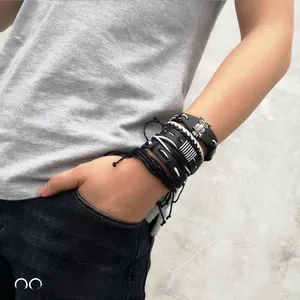 Detail of multi-layer men's braided leather bracelet with silver owl charm on wrist
