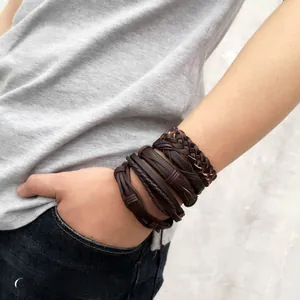 Detail of vintage multilayer braided leather bracelets set for men in dark brown