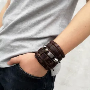 Detail of vintage multilayer leather bracelets with braided ropes on man's wrist