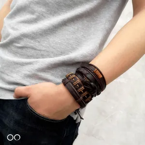 Detail of vintage men's multi-layer braided leather bracelets on wrist in casual style