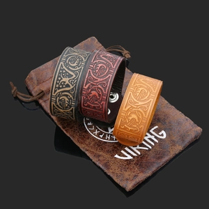 Detail of vintage Viking leather bracelets set with embossed patterns and button snaps