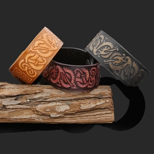 Detailed view of handmade leather wristbands with embossed dragon patterns in three colors