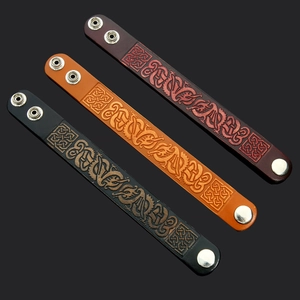 Handmade punk leather bracelets with Nordic dragon embossing in black, red, and brown