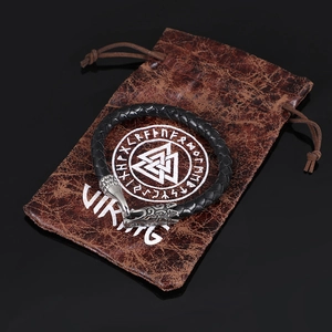 Detailed close-up of Viking raven head buckle on black braided leather bracelet with pouch