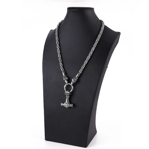 Detail of Viking Thor's Hammer Mjölnir pendant with wolf heads and heavy chain