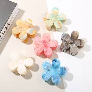 Flat lay of flower shaped hair claws with marble texture in six assorted pastel colors