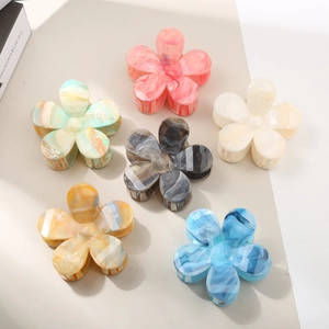 Detailed view of six floral hair claws in gradient colors with marble textures