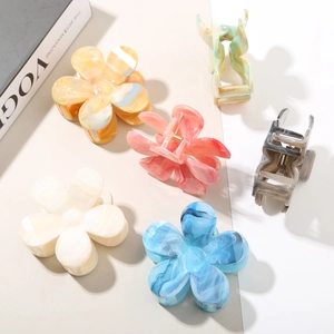 Close-up of assorted acetate flower hair claws with elegant marble textures and strong metal springs