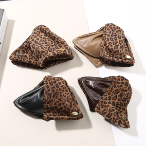 Close-up of four leopard print storage pouches with gold logo charms and diverse linings