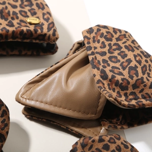 Macro shot of leopard print faux fur fabric with premium brown leather and gold PODA logo buckle