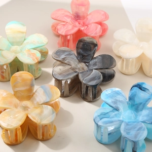 Detailed top view of flower-shaped acrylic hair claws in assorted marble and solid colors