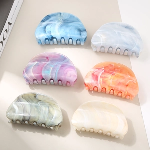 Detail showing six colorful marble pattern hair claws with elegant gradient floral textures