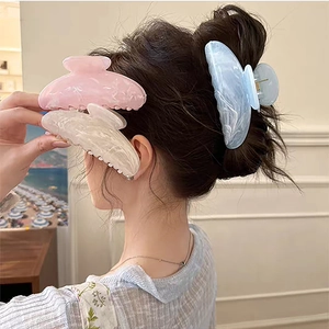 Detail of elegant marble texture on large claw clips for thick hair in soft pastel shades