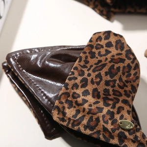 Detailed close-up of brown leopard print hair claw with a gold metal brand logo plate