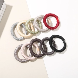 Detail of ten colorful satin silk hair scrunchies with elegant glossy decorative beads